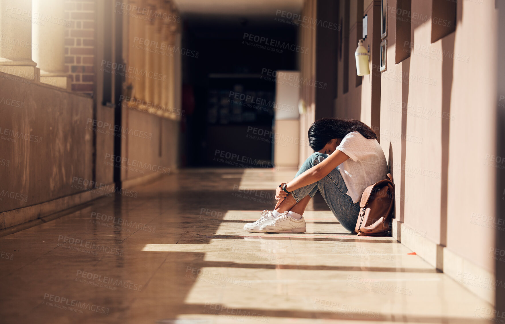 Buy stock photo Sad, lonely and girl with depression at school, crying and anxiety after bullying. Mental health, tired and unhappy student in the corridor after problem in class, education fail and social isolation