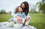 Love, mother and girl on blanket at park, having fun and bonding. Care, family and happy mom embrace with 
daughter at garden, smiling and enjoying quality time together outdoors in nature on grass.