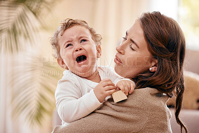 Buy stock photo Shot of a woman comforting her baby at home