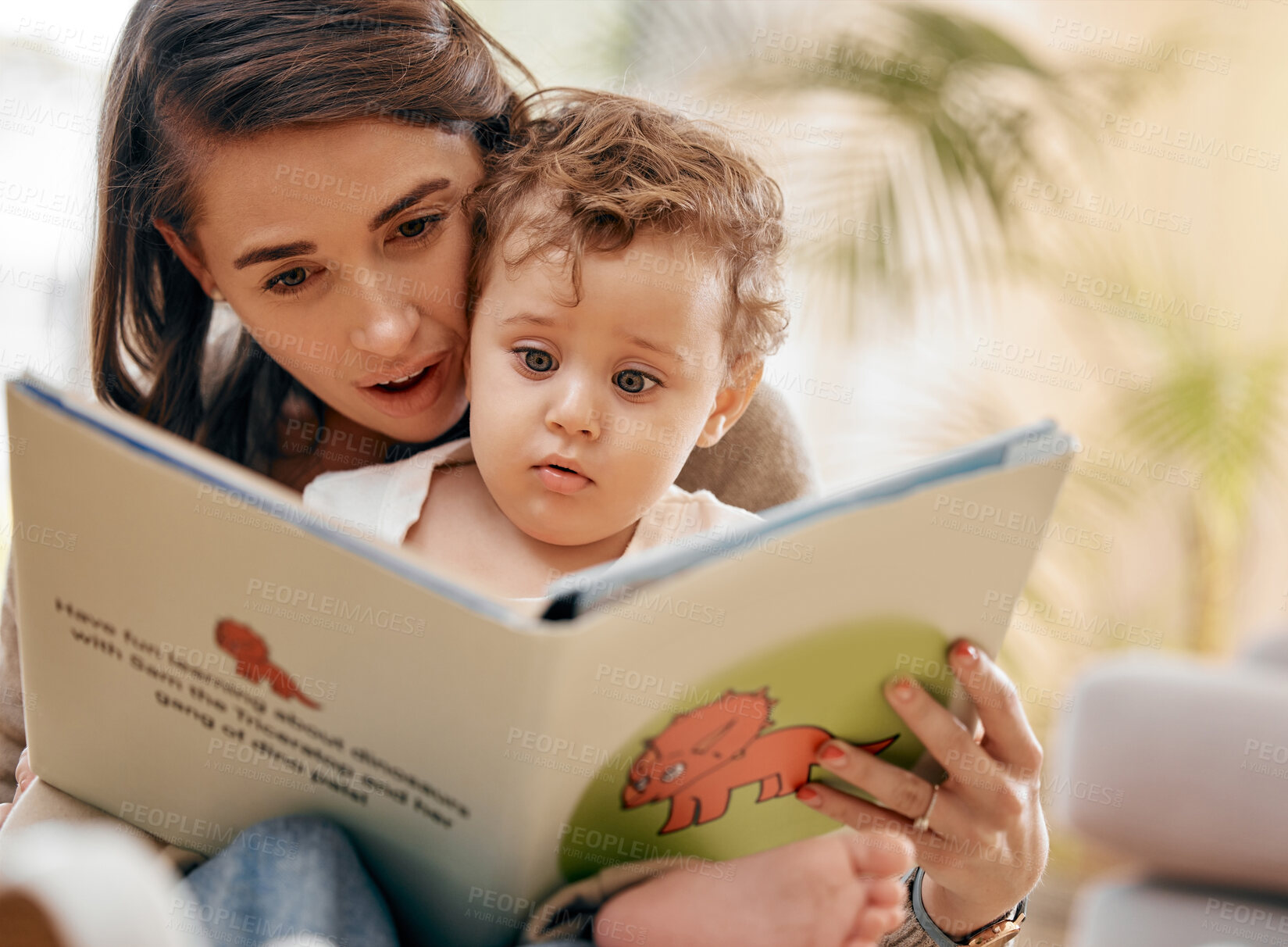 Buy stock photo Shot of a mother reading a book to her son at home