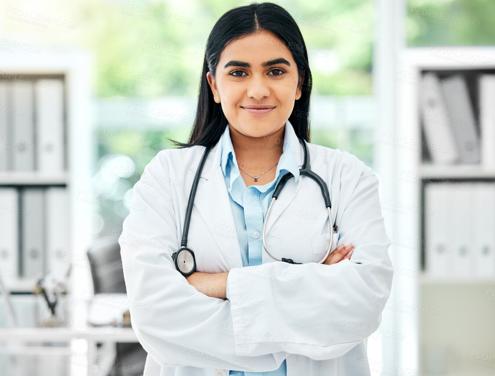 Buy stock photo Portrait of a doctor working in her office with medical equipment at a modern surgery center. Happy healthcare worker standing with a stethoscope in hospital after a health and wellness consultation.