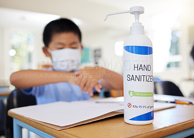 Buy stock photo Boy rubbing hand sanitizer for hygiene, safety and protection against covid at school. Closeup bottle of alcohol gel on desk in classroom to clean, kill or prevent the spread of germs or coronavirus