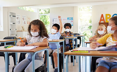 Buy stock photo Young kids learning in classroom after covid pandemic, wearing protective face masks. Little children sitting in school with raised arm to ask questions and studying for their education