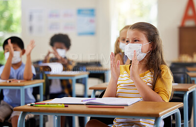 Buy stock photo Safety, compliance and education in classroom at school with students wearing masks during corona pandemic. Young learners clapping, excited and attentive during and educational lesson on hygiene
