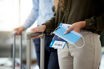 Buy stock photo Closeup of a woman at the airport to travel during the covid pandemic with luggage in hand. Business female traveling for work standing with passport, plane ticket and face mask to board the airplane