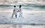 Love, beach and travel couple happy walking in water, by the ocean or waves together bonding on holiday or vacation. Man and woman holding hands during honeymoon smiling in the sea.
