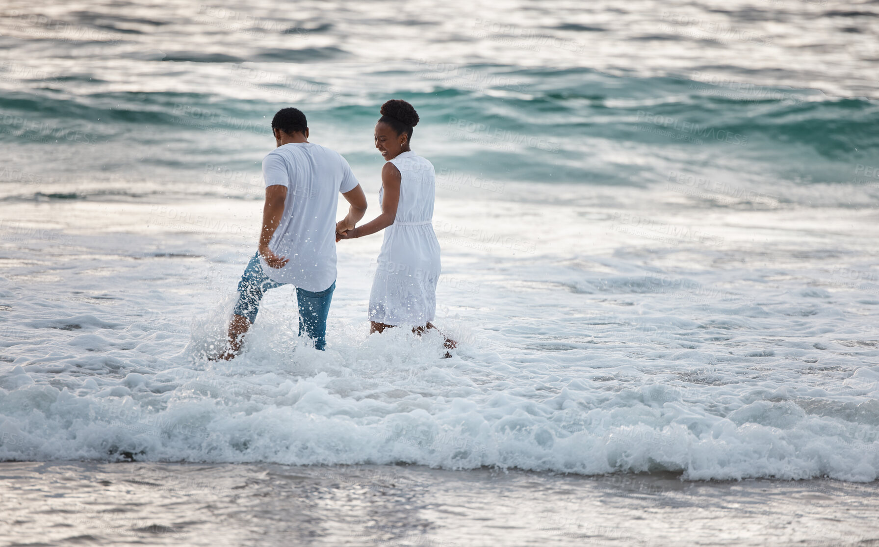 Buy stock photo Love, beach and travel couple happy walking in water, by the ocean or waves together bonding on holiday or vacation. Man and woman holding hands during honeymoon smiling in the sea.