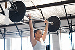 Woman athlete, fitness and workout in a gym while lifting heavy weight while a cardio exercise. Health, wellness or motivation in training with a strong, healthy and powerful woman with weightlifting