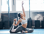 Yoga, gym or workout by a fit woman stretching for her exercise or workout routine in a fitness club. Young flexible woman training, exercising or practicing for a gymnastics competition