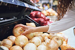 Vegetables, grocery shopping and health while a customer choose fresh onions in supermarket or greengrocer store. Close up hands of woman buying vegan food groceries before inflation at retail market