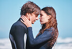 Young surfing couple hug, share intimate moment on beach vacation, flirting and playful. Girlfriend and boyfriend embracing, enjoying their romance and relationship while being free together outside
