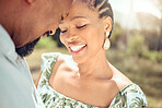 Love, black couple and forehead touch in nature with a smile on holiday or date. Happy black man and woman, romantic African people or lovers bonding in affection together in the shining summer sun.
