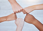 Fist bump, unity and support group touching hands in a circle at a community therapy session. Top view of friends doing team building, care and trust exercise while bonding at  a fellowship event.