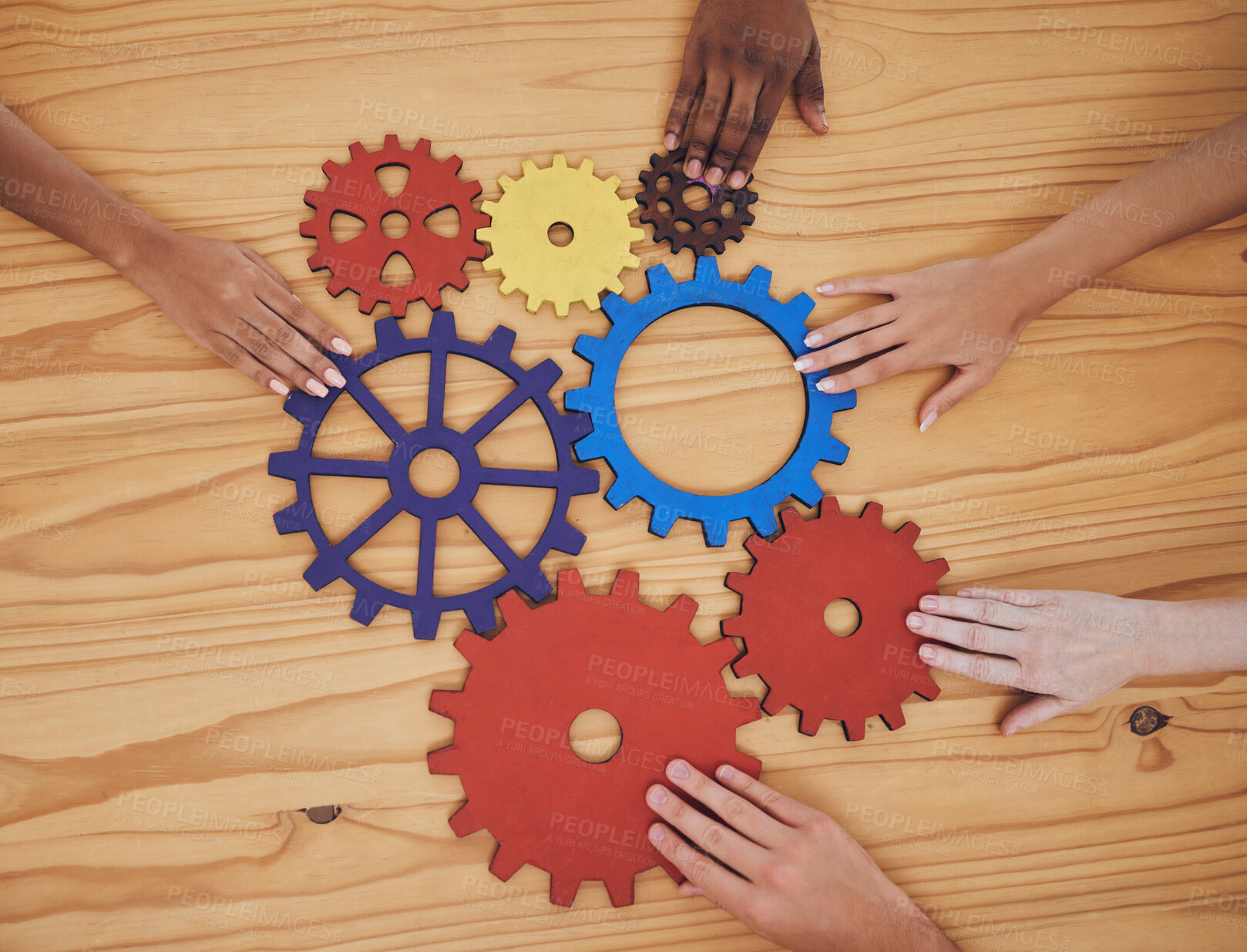 Buy stock photo Hands, gears and collaboration with a team of people working with cogs and equipment on a table in the office. Teamwork, synergy and planning with a business group meeting to talk company strategy