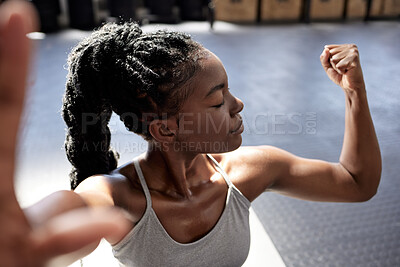 Fitness, strong and black woman flexing her muscle at the gym in a  training, exercise and workout motivation portrait. Healthy, wellness and  young athlete with powerful body, arms and muscular biceps