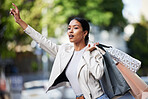 Retail, shopping and transport by black woman showing hand sign for a taxi in an urban city. Female shopper looking fashionable with bags of discount sale purchase, waiting for a cab downtown