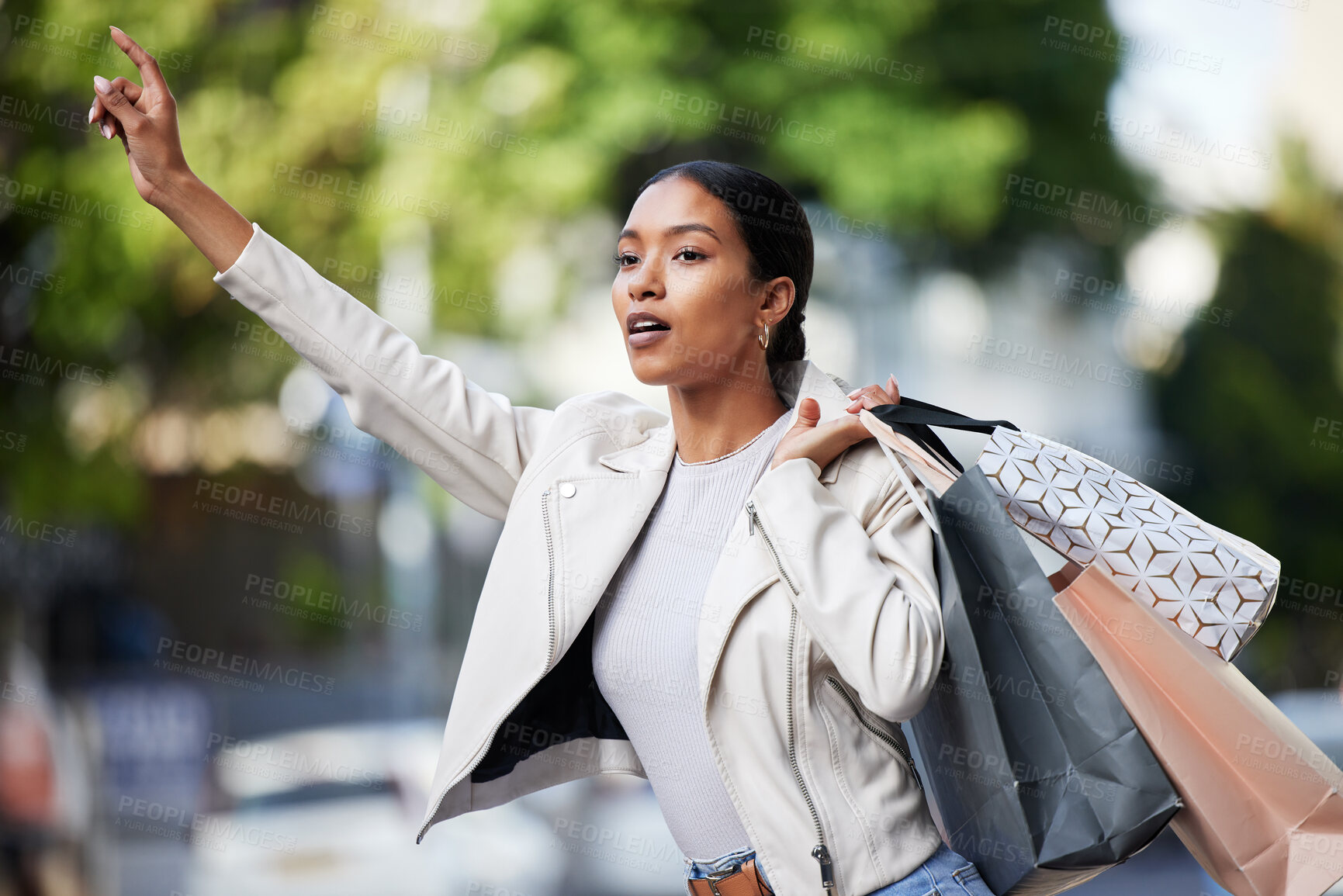 Buy stock photo Retail, shopping and taxi with black woman showing hand sign for transport in an urban city. Female shopper looking fashionable with bags of discount sale purchase, waiting for a cab downtown