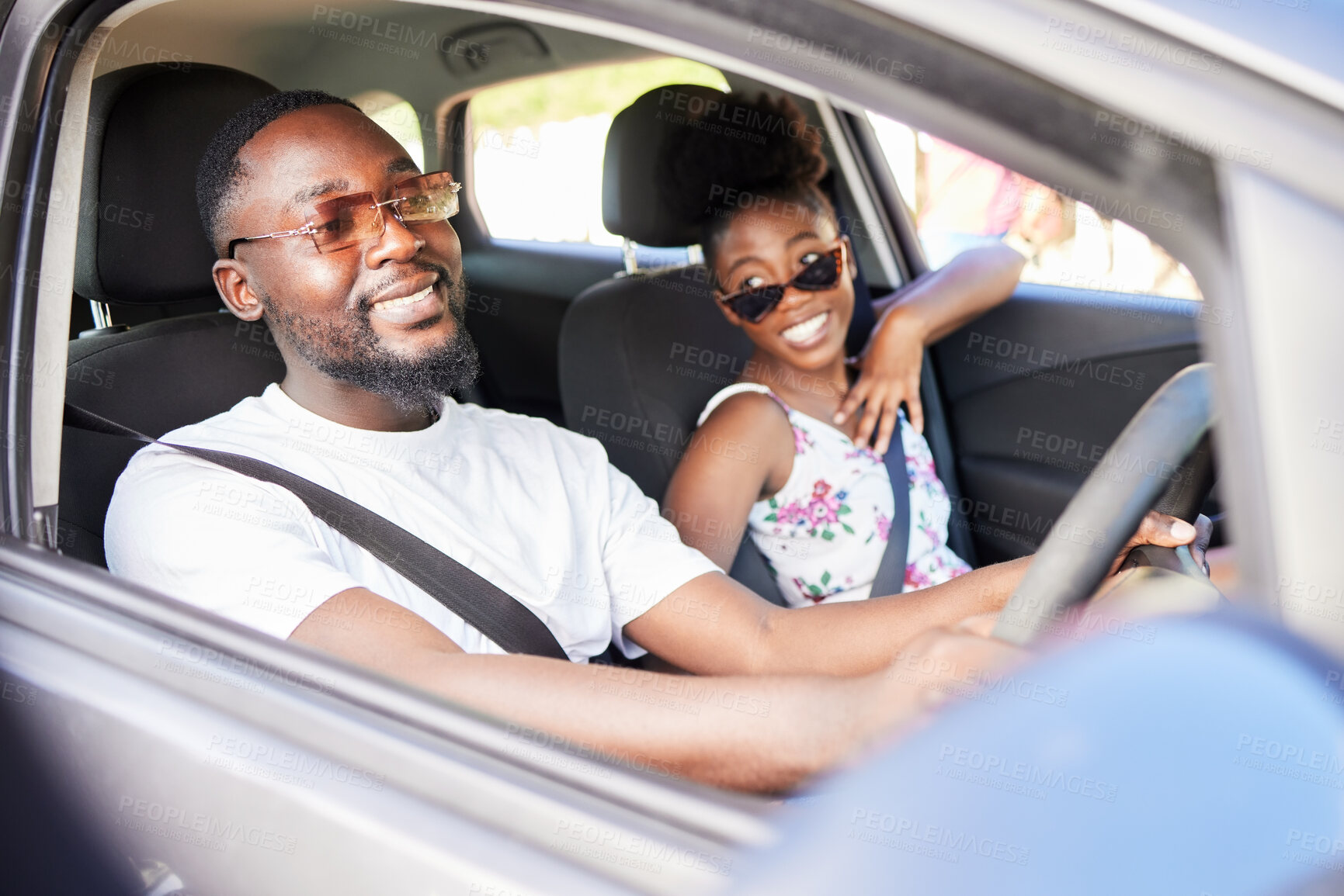 Buy stock photo Happy black couple on road trip, bonding and discussing their holiday or vacation ahead. Cheerful African American man and woman enjoying time together, having fun on their driving adventure