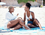 Travel, friends and summer fun with happy black women bonding at beach, laughing and talking while sitting together. Young females enjoying their vacation, excited and having fun outdoors at seaside