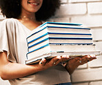 Education, knowledge and learning student with books for studying, research or assignment on a white wall. Black scholarship, geek or nerd girl with stack of university library textbooks for reading