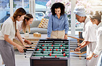 Table football, soccer or foosball as women play a fun game together during their lunch break at work. Entertainment, happy and female friends in a friendly match competition on office free time