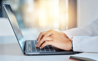 Buy stock photo Doctor hands typing on a laptop doing medicine research at a hospital table and reading email online at work. Healthcare expert or medical professional using keyboard and consulting via the internet