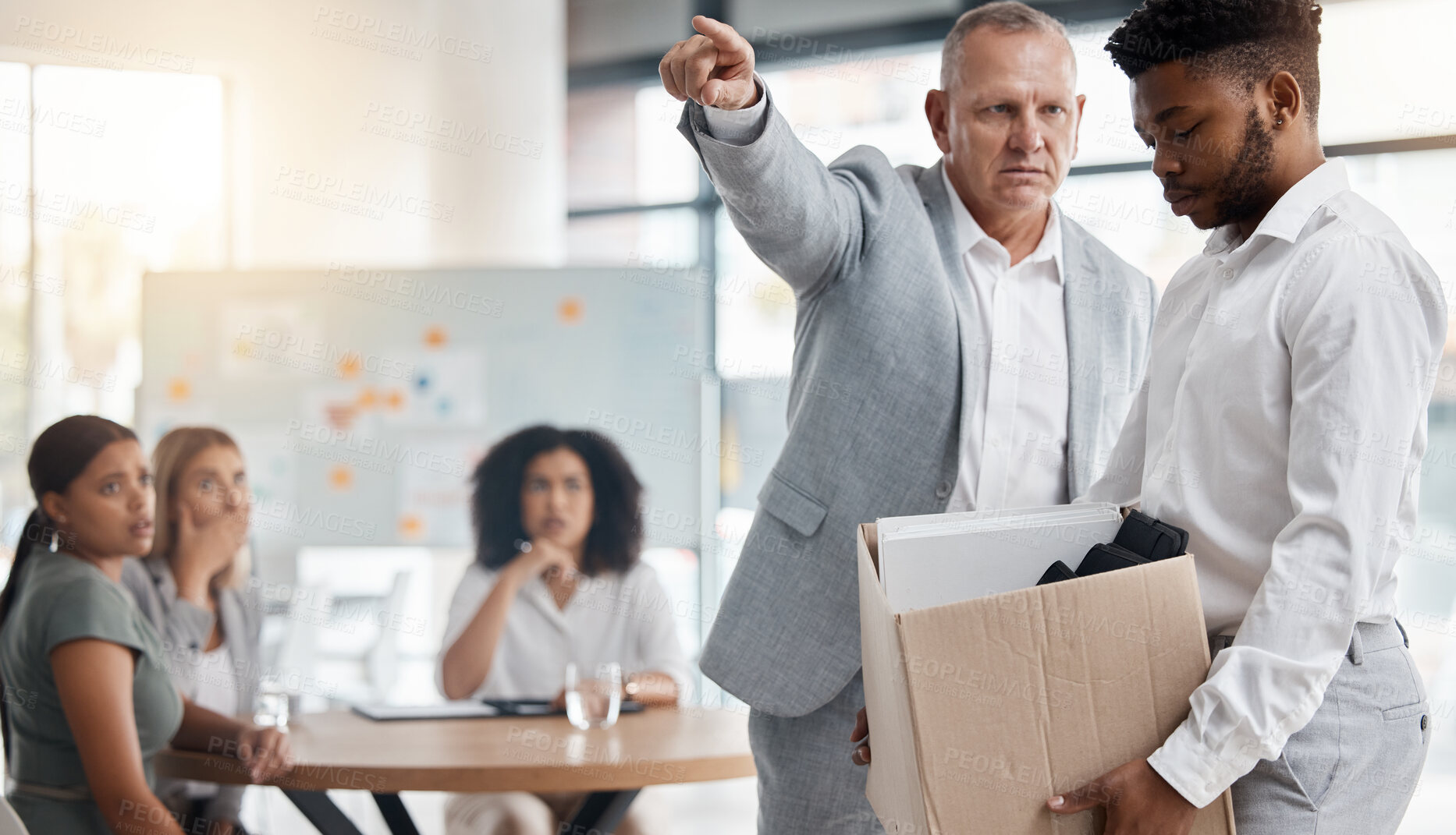 Buy stock photo Black man, sad and fired by boss in a meeting holding a box in disappointment at the office. Manager or company leader pointing to the exit and firing employee in front of colleagues at the workplace