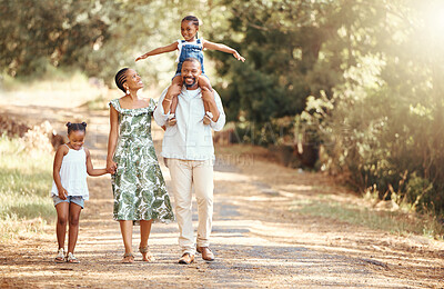 Buy stock photo Happy black family bonding on an outdoor work in a park, loving and having fun together. African American parents enjoying fresh air and an active walk with their children, playful, cheerful and free