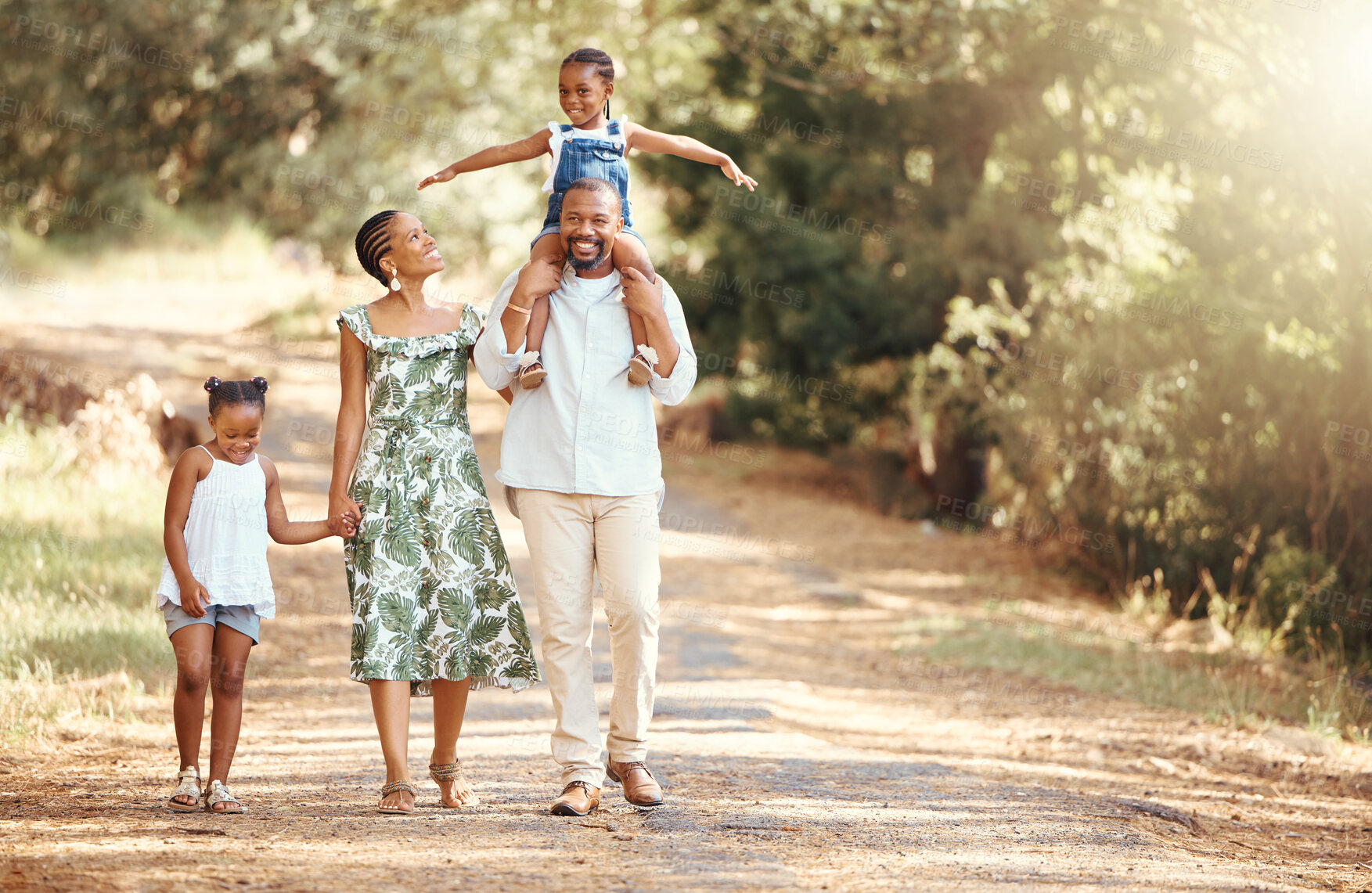 Buy stock photo Happy black family bonding on an outdoor work in a park, loving and having fun together. African American parents enjoying fresh air and an active walk with their children, playful, cheerful and free
