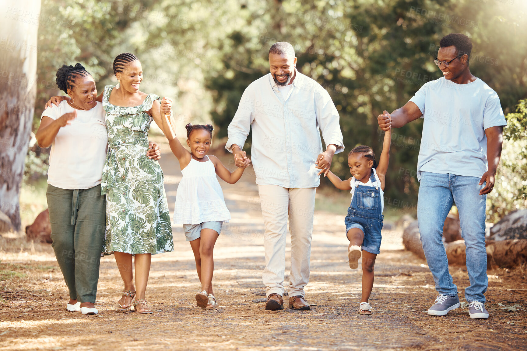 Buy stock photo Black family, hiking or bond with children, parents or grandparents walking in remote nature forest and countryside. Happy mother, father or senior holding hands with girls and skipping in tree park 
