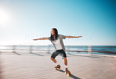 Buy stock photo Man roller skating on the promenade at the beach during a summer holiday for fun and exercise. Young, fit and healthy guy skating for a fitness workout on boardwalk in nature by the ocean on vacation