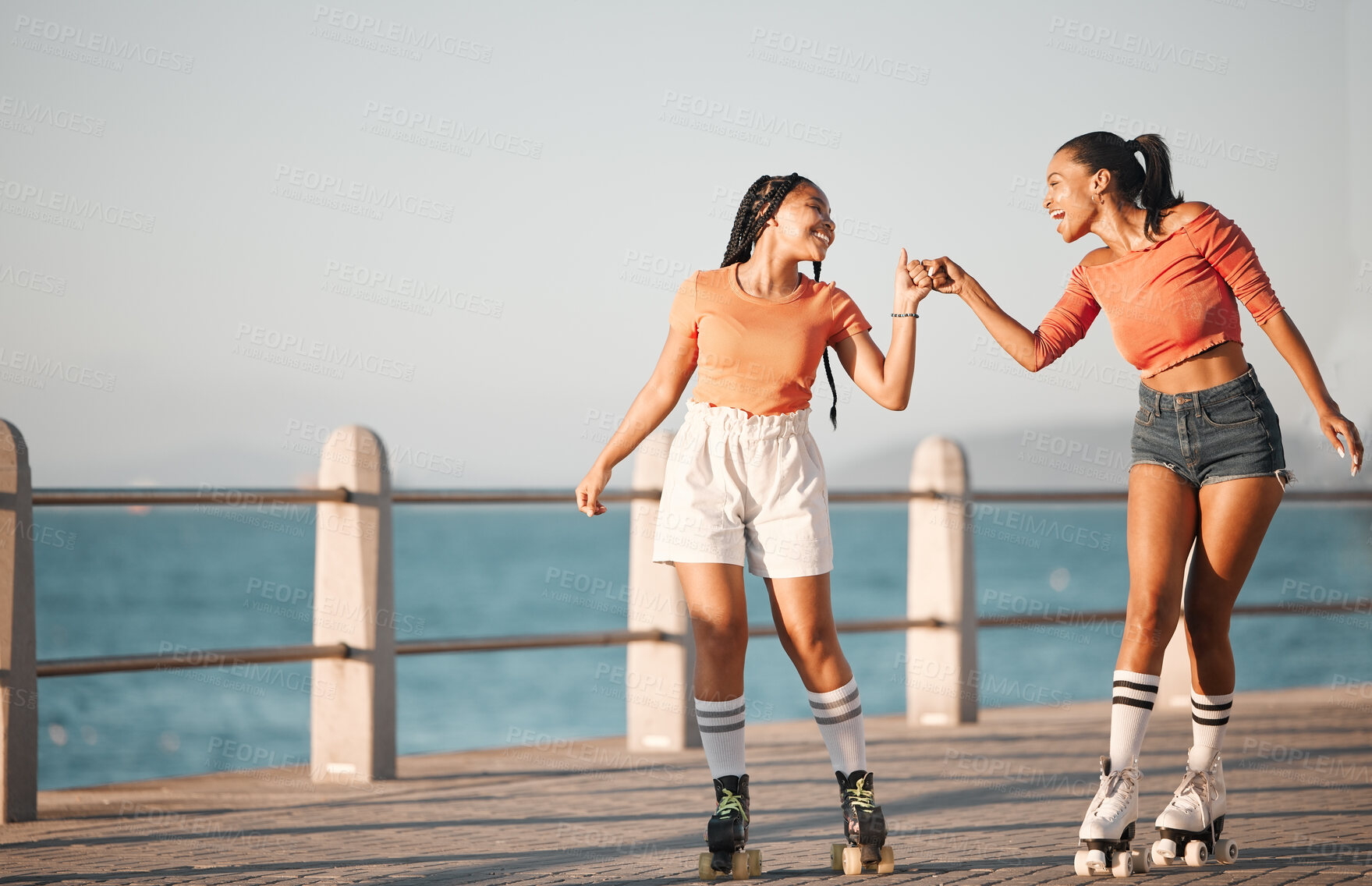Buy stock photo Girl, women or friends roller skate on sea, water or ocean sidewalk together for fun travel and relax adventure ride. Fist bump, friendship and journey for fitness, exercise and skate training cardio