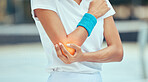 Tennis elbow, pain and injury with a sports woman holding her joint during training, workout and exercise. Fitness, health and accident with a female athlete i a game or match on a court outside