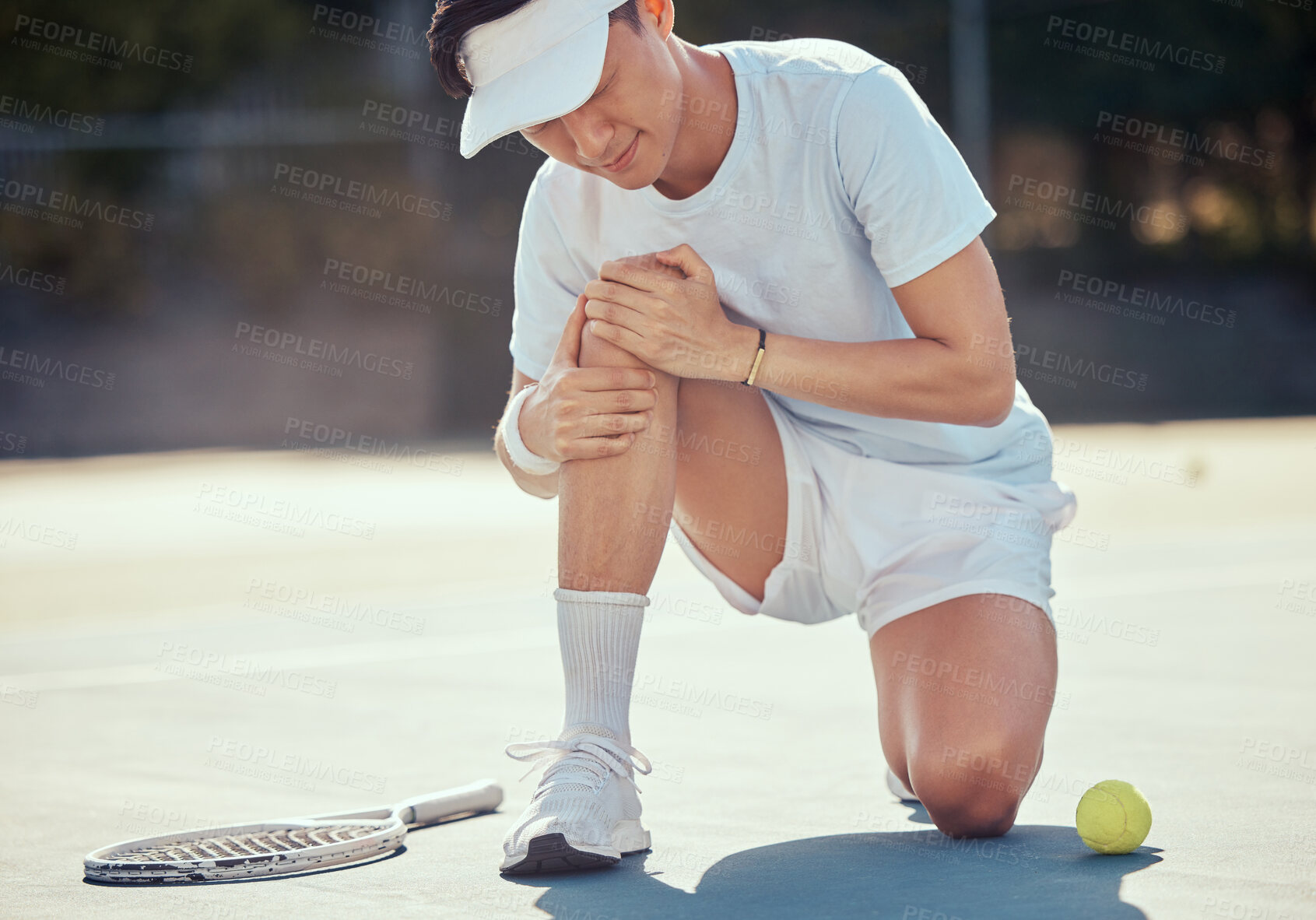 Buy stock photo Sport, pain and tennis injury by athlete man holding knee during a competitive match at outdoor court. Professional asian tennis player suffering from hurt muscle, fitness accident while exercising