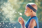 Boy, blowing a dandelion and making a wish with a black child outside on a basketball court while holding a magical flower. African kid enjoying freedom, harmony and dream to be a professional player
