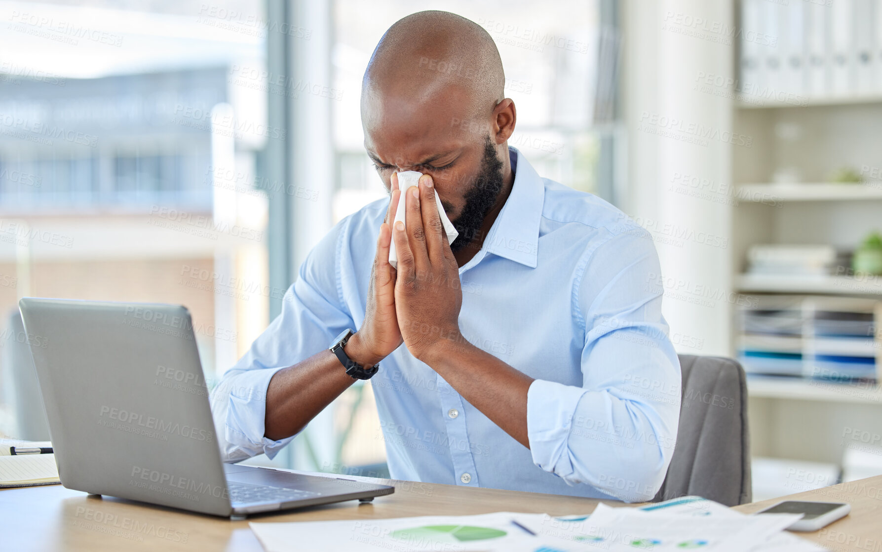 Buy stock photo Black man, covid and flu in office by laptop, desk or research documents in company. Sick businessman or worker blowing nose with tissue, suffering from healthcare virus and medical wellness crisis