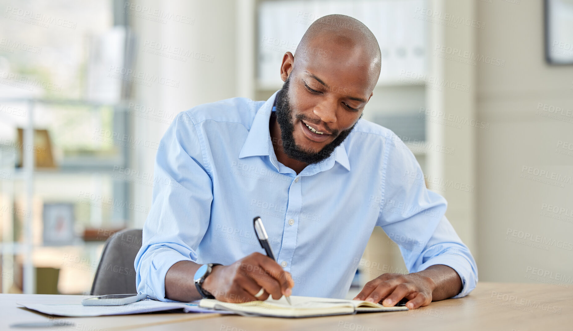 Buy stock photo Businessman writing in a notebook while planning a strategy and working in an office. Happy male professional reading and write market search result and work updating schedule at a corporate company