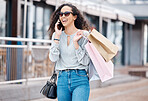 Shopping, happy and woman on a phone call about fashion discount, promotion and sales deal in retail market. Freedom, smile and customer walking with bags of clothes talking about offer in city mall 