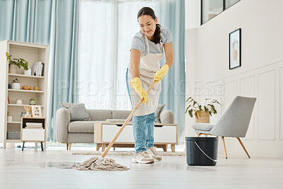 Buy stock photo Woman cleaning the floor with a mop in the living room in home with a smile. Happy asian cleaner doing housework or job in a clean lounge, hotel room or house while smiling and alone spring cleaning