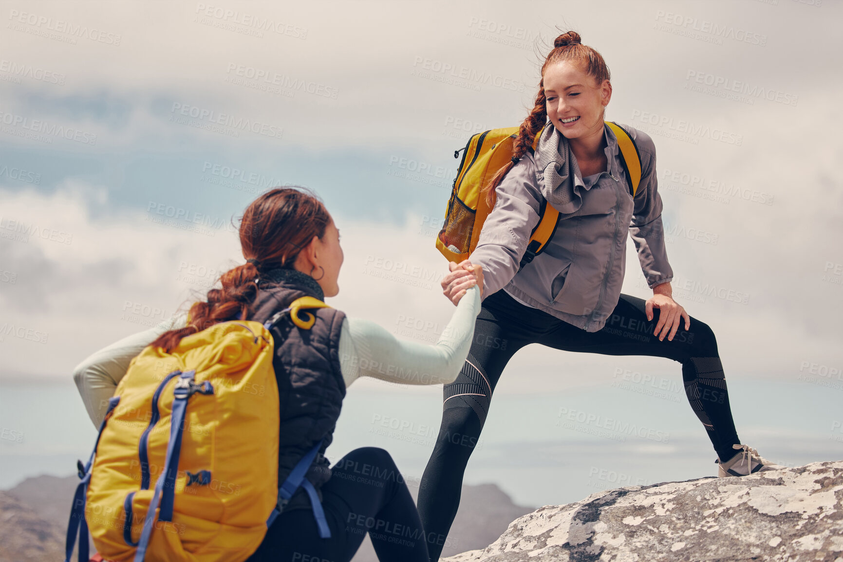 Buy stock photo Help hands, friends or women hiking up a mountain, hill or in nature with a smile. Travel, adventure and trekking females on an outdoor, countryside or rock climbing recreation exercise activity.