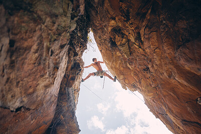 Buy stock photo Mountain or rock climbing, cliff hanging and adrenaline junkie with courage on adventure trying to balance between gap. Athletic climber man doing fitness, exercise and workout during extreme sport
