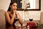 Wine, candle and roses, a woman waiting for date in a romantic restaurant. Engagement or valentines, a beautiful lady, sad and annoyed alone at a table. Rose petals, disappointment and a romance fail