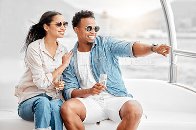 Buy stock photo Happy couple on a luxury boat with a glass of champagne while on the ocean or sea during summer. Young man and woman drinking wine while sailing on a yacht or cruise on expensive vacation.