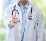 Thumbs up, doctor and hand of woman or medical worker on a blurred background. Healthcare expert finger, like or approval hands, okay or success, welcome or motivation, yes signal and thank you sign