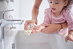 Mother washing kids hands with sanitizer liquid soap after baby toddler had dirty fingers in the sink. Healthy, kindergarten and mom cleaning and helping a young girl with hygiene wellness at home