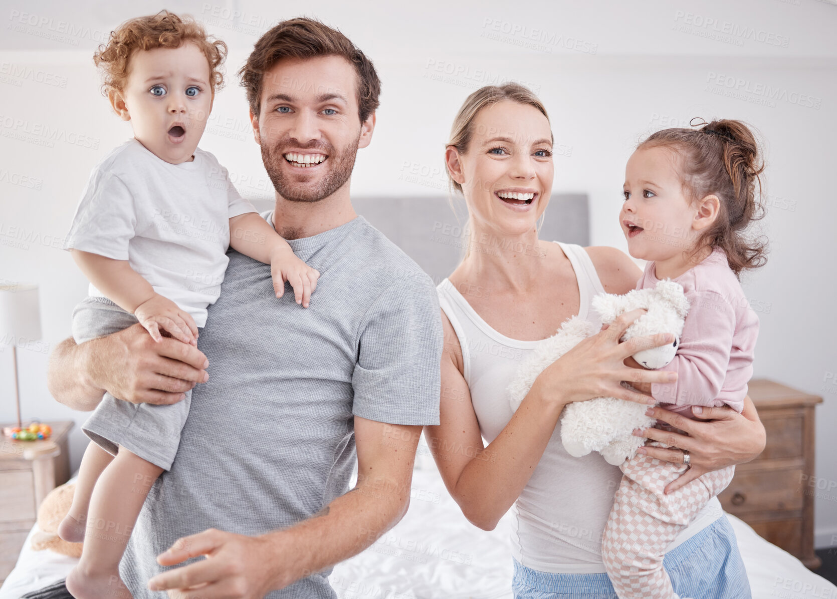 Buy stock photo Portrait of happy family in bedroom with kids, love and a smile at home, house or room. Care, support and trust of married people bonding and caring for their cute baby boy, girl or children together