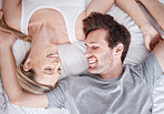 Happy white couple, smile and bed relaxing together in happiness for relationship, bonding and care above at home. Man and woman smiling in love, lying and relax for bedroom time and break in comfort