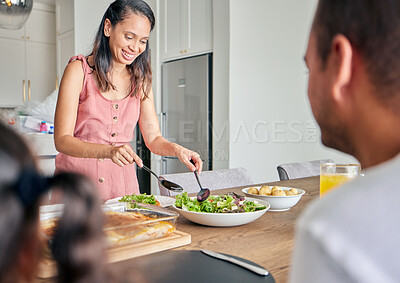 Buy stock photo Wife, mom and healthy food with a woman serving lunch or supper for her family with a smile at home. Happy housewife preparing green salad and enjoying a vegan meal at the table together