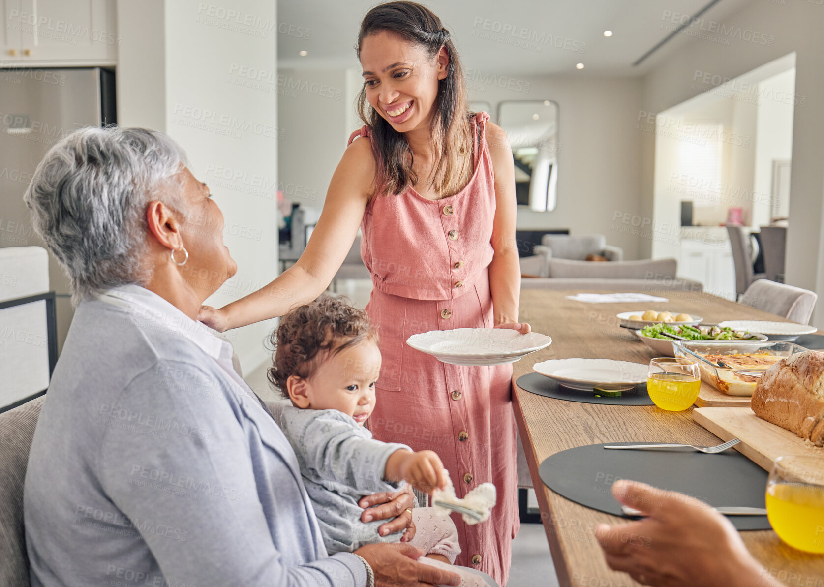 Buy stock photo Mom, baby and grandmother eating at table, bonding and sharing food and love at home. Happy, smile and relax women bonding while having a meal, enjoying family time and being loving and caring