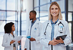 Woman, team and portrait of doctor with tablet in the hospital. Female doctor, smiling and diversity in healthcare, medicine and medical care with doctors smiling, standing and talking 